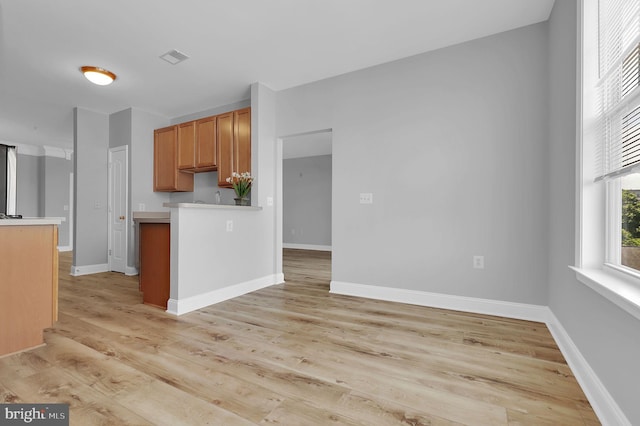 503 King Farm Blvd Unit 306, Rockville, MD 20850 - kitchen featuring light countertops, light wood-style flooring, baseboards, and a peninsula