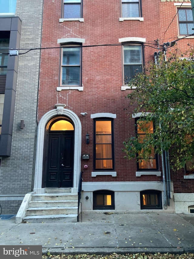 doorway to property featuring brick siding