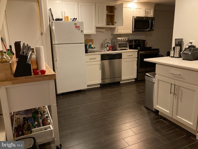 kitchen featuring light countertops, open shelves, appliances with stainless steel finishes, wood tiled floor, and white cabinets