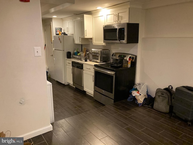 kitchen featuring white cabinets, light countertops, appliances with stainless steel finishes, and wood finish floors