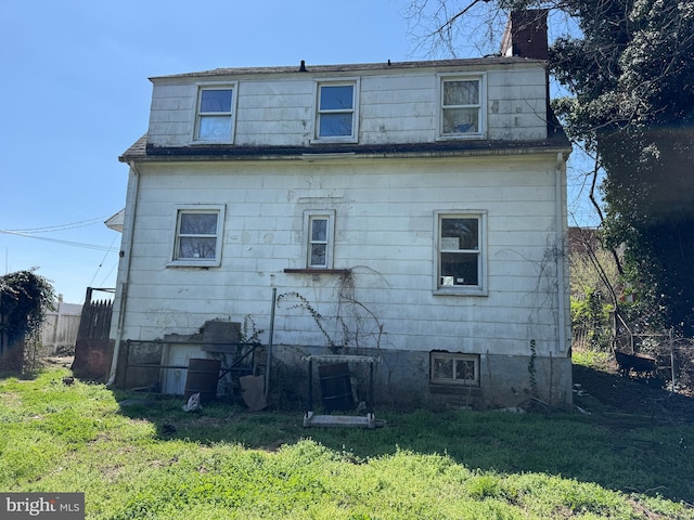 605 Walnut Ave, Baltimore, MD 21229 - back of house with roof with shingles, fence, mansard roof, a yard, and a chimney