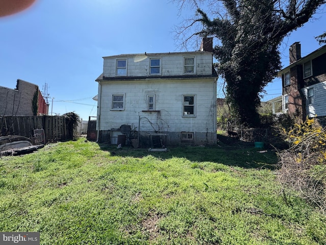 605 Walnut Ave, Baltimore, MD 21229 - rear view of house with mansard roof, fence, a yard, and a chimney