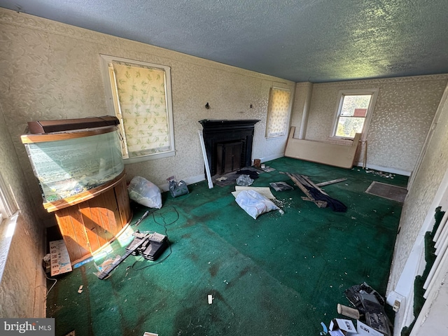 605 Walnut Ave, Baltimore, MD 21229 - unfurnished living room featuring a fireplace, carpet floors, a textured ceiling, and wallpapered walls