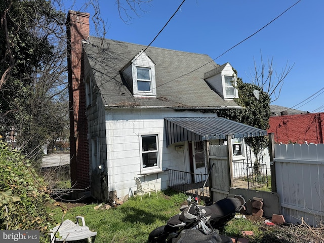605 Walnut Ave, Baltimore, MD 21229 - exterior space featuring a chimney, fence, and roof with shingles
