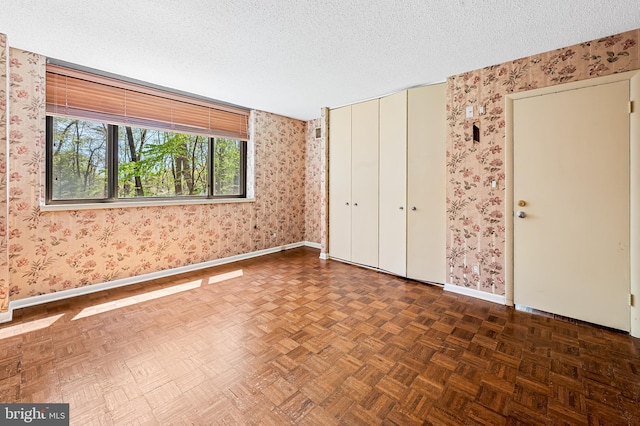 unfurnished bedroom featuring wallpapered walls and baseboards