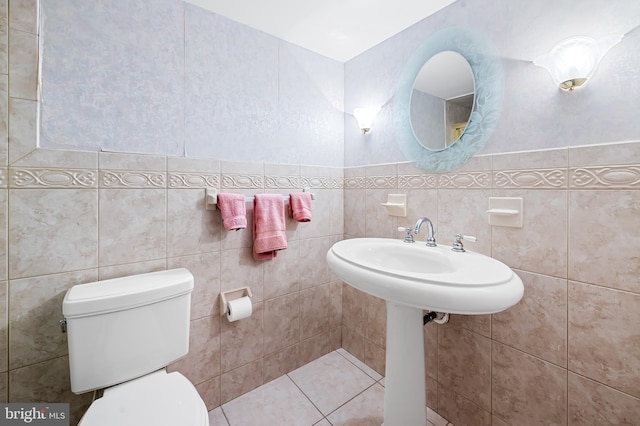 bathroom featuring toilet and tile walls