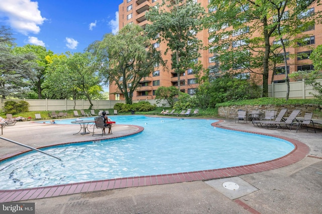 community pool featuring fence and a patio area