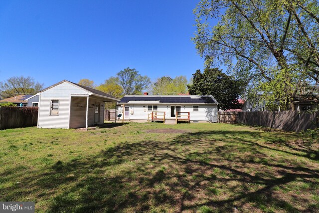 1405 Westchester St, Salisbury, MD 21801 - rear view of property with an outbuilding, a fenced backyard, solar panels, and a lawn