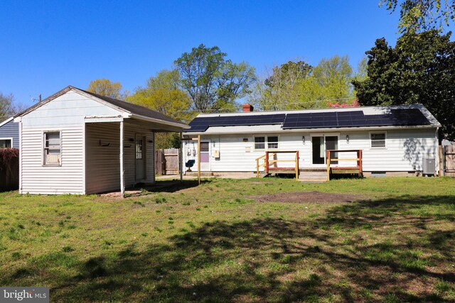 1405 Westchester St, Salisbury, MD 21801 - back of house with a yard, a wooden deck, roof mounted solar panels, and central AC