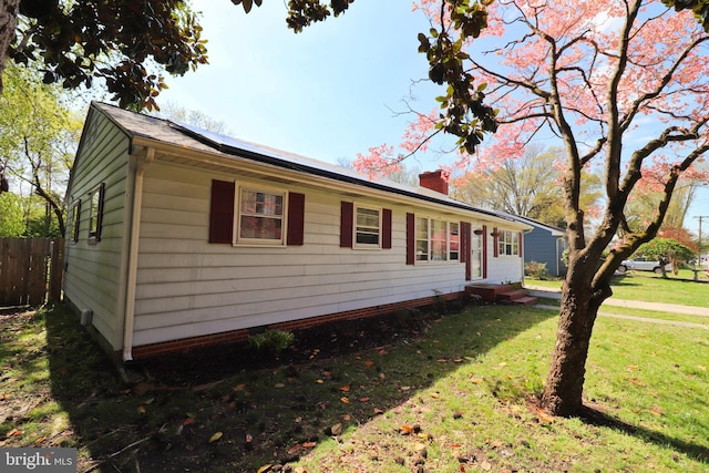 1405 Westchester St, Salisbury, MD 21801 - view of side of home featuring roof mounted solar panels, entry steps, a lawn, a chimney, and fence