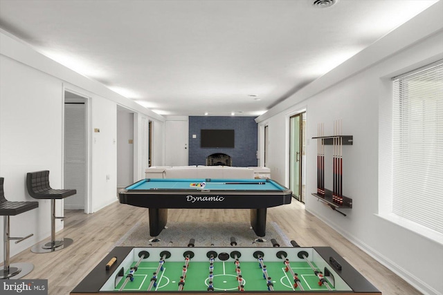 rec room with wood finished floors, pool table, a brick fireplace, and baseboards