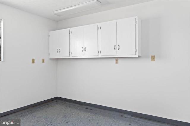 clothes washing area featuring baseboards