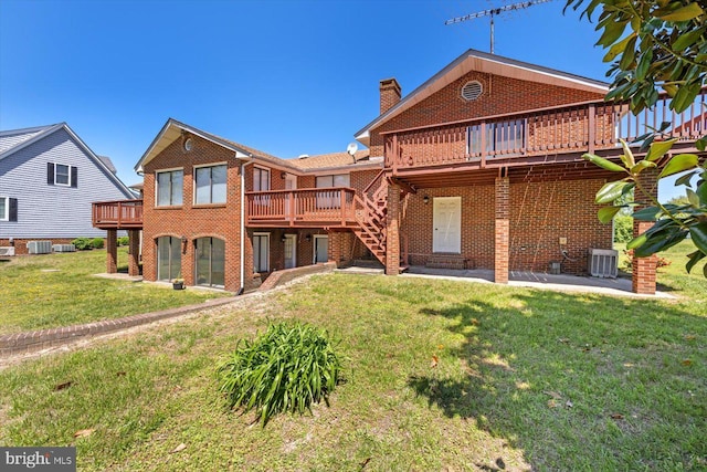 back of property featuring brick siding, a deck, a chimney, and a yard