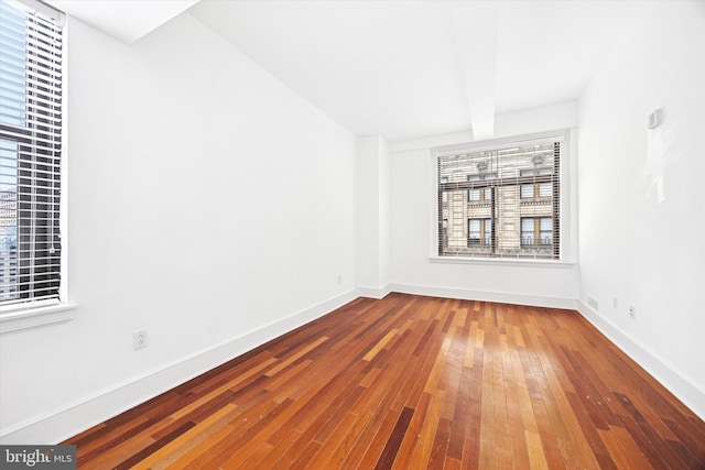 1500 Chestnut St Unit 15H, Philadelphia, PA 19102 - spare room with beamed ceiling, baseboards, and hardwood / wood-style floors