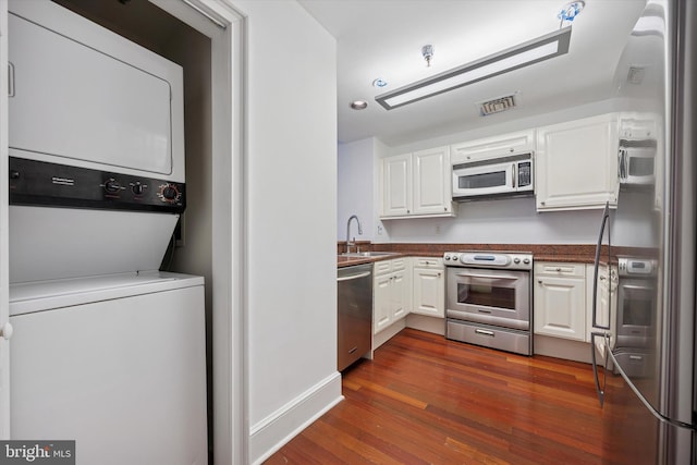 1500 Chestnut St Unit 15H, Philadelphia, PA 19102 - kitchen featuring visible vents, white cabinets, stacked washing maching and dryer, and stainless steel appliances