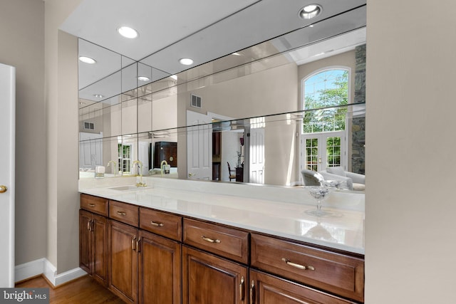 bathroom with visible vents, vanity, wood finished floors, baseboards, and recessed lighting