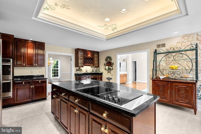 kitchen with stainless steel double oven, a raised ceiling, and black electric stovetop
