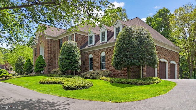 view of property exterior featuring a yard, brick siding, and a garage