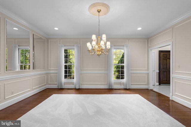unfurnished dining area featuring a notable chandelier, a wealth of natural light, and a decorative wall