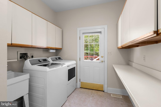 washroom with cabinet space, light tile patterned flooring, washing machine and clothes dryer, baseboards, and visible vents