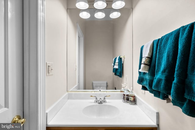 half bathroom with vanity and toilet
