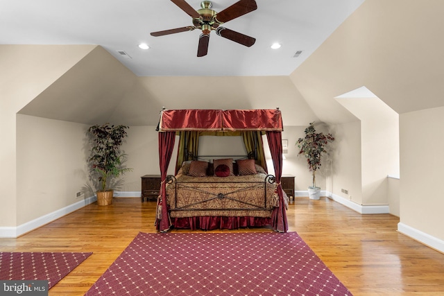 bedroom featuring visible vents, baseboards, lofted ceiling, and wood finished floors