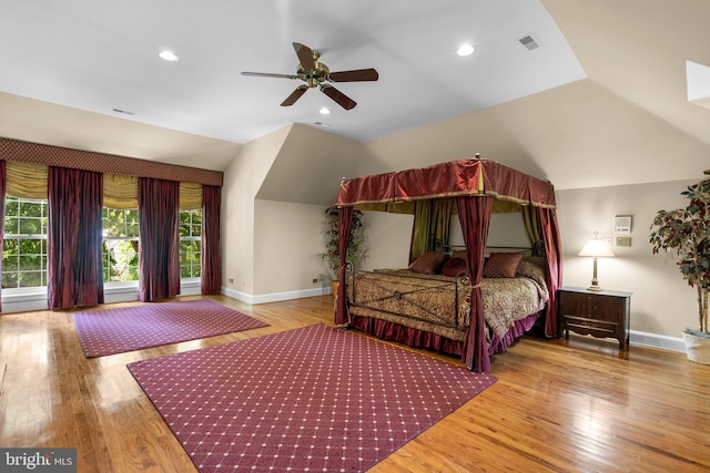 bedroom with baseboards, visible vents, wood finished floors, and lofted ceiling