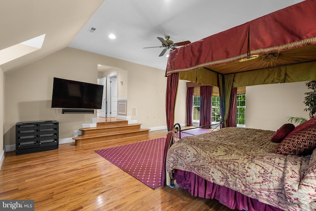 bedroom featuring visible vents, wood finished floors, baseboards, recessed lighting, and vaulted ceiling with skylight