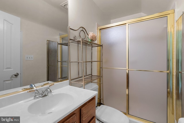full bathroom featuring toilet, a shower with door, and vanity