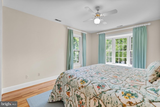 bedroom featuring multiple windows, wood finished floors, and visible vents