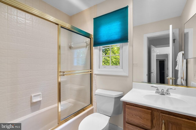 bathroom with vanity, combined bath / shower with glass door, and toilet