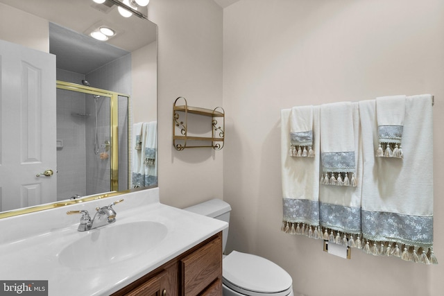 bathroom with toilet, a shower stall, and vanity