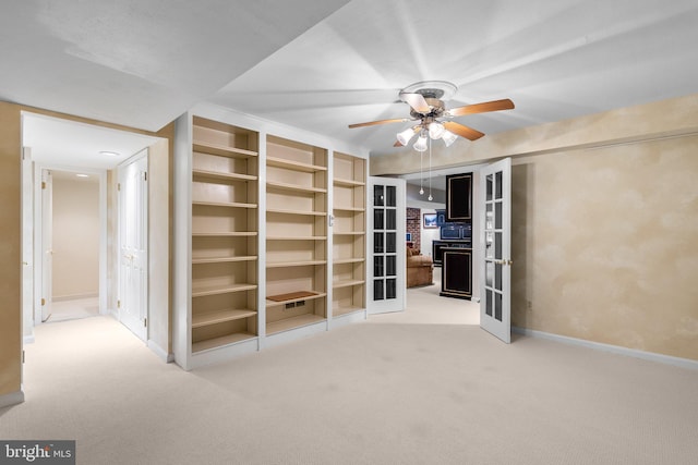 carpeted empty room featuring baseboards, ceiling fan, and french doors