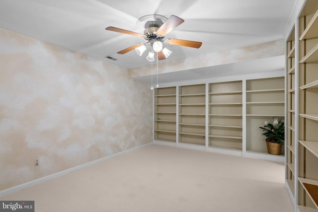 spare room featuring carpet floors, baseboards, visible vents, and ceiling fan