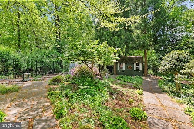 view of yard with fence, an outdoor structure, and a storage shed