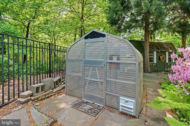 view of greenhouse featuring fence