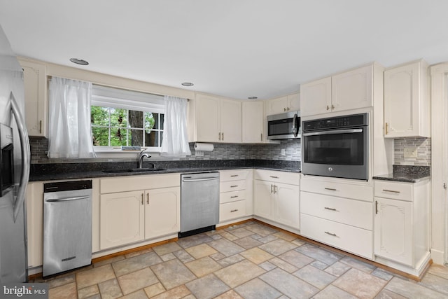 669 Dicks Hollow Rd, Winchester, VA 22603 - kitchen featuring stainless steel appliances, a sink, tasteful backsplash, stone finish flooring, and cream cabinetry