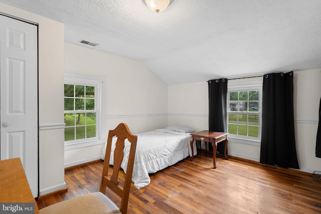 669 Dicks Hollow Rd, Winchester, VA 22603 - bedroom featuring a textured ceiling, lofted ceiling, wood finished floors, multiple windows, and baseboards