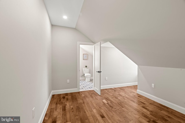 bonus room with baseboards, vaulted ceiling, and wood finished floors