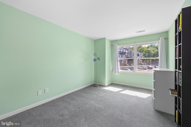 spare room with visible vents, carpet flooring, and baseboards