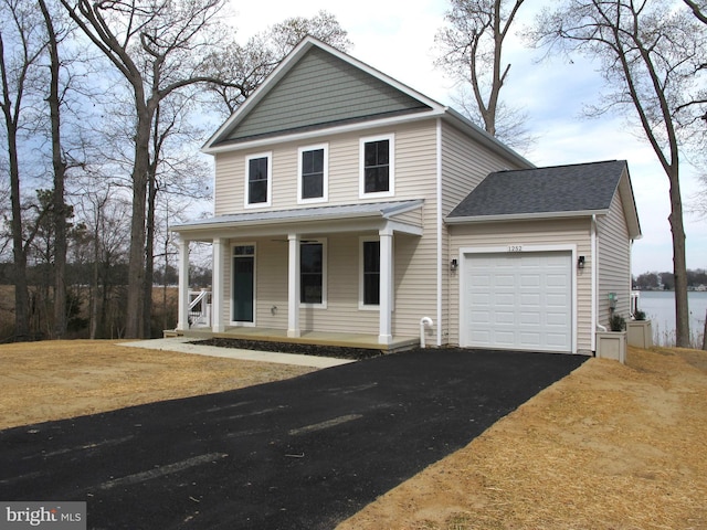 view of front facade with driveway, a shingled roof, covered porch, and a garage