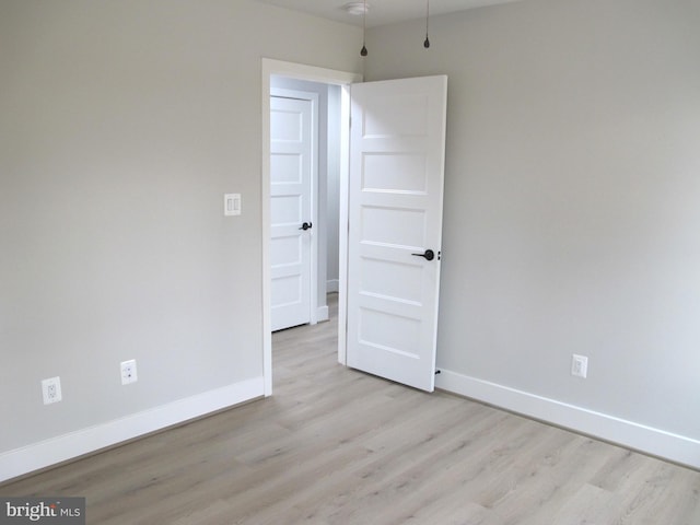 spare room featuring baseboards and wood finished floors