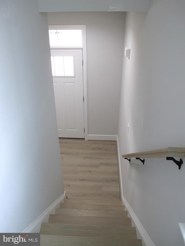 stairway with baseboards and wood finished floors