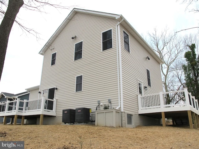 back of house featuring central AC unit and a deck