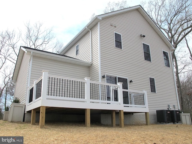 rear view of property featuring central AC unit and a wooden deck
