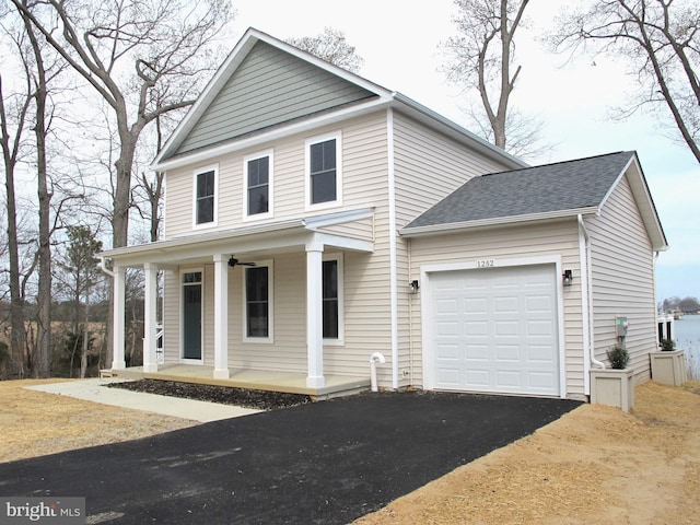 view of front of home featuring driveway, an attached garage, a porch, and a ceiling fan