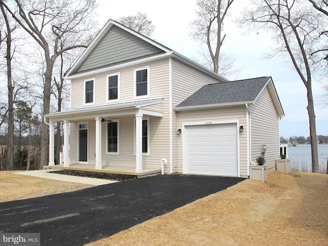 view of front facade featuring covered porch, a garage, aphalt driveway, and a shingled roof