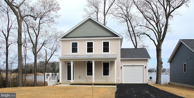 traditional-style house with a porch, driveway, a garage, and a shingled roof
