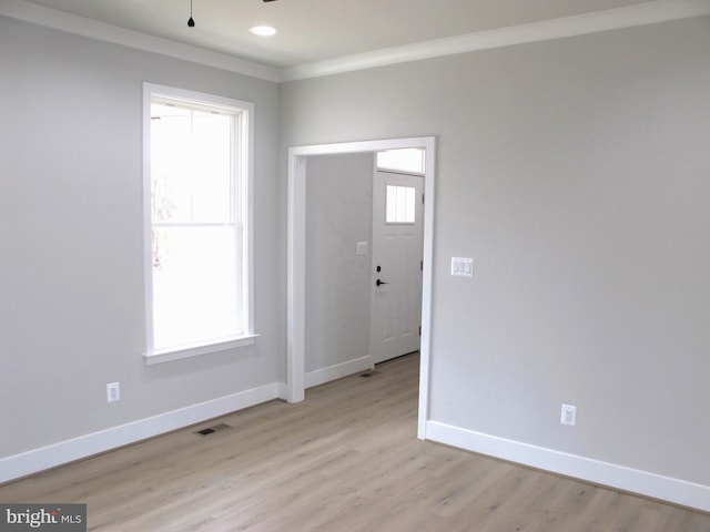 interior space featuring light wood-style flooring, visible vents, crown molding, baseboards, and ceiling fan