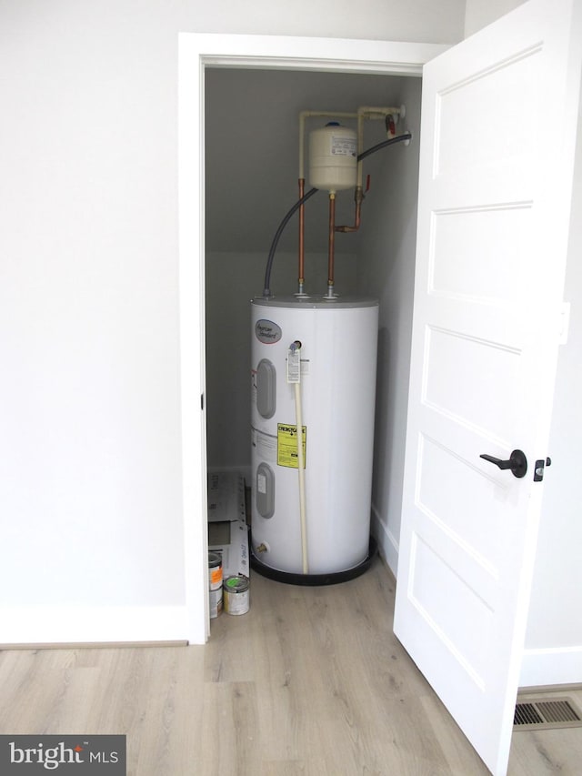 utilities with water heater and visible vents